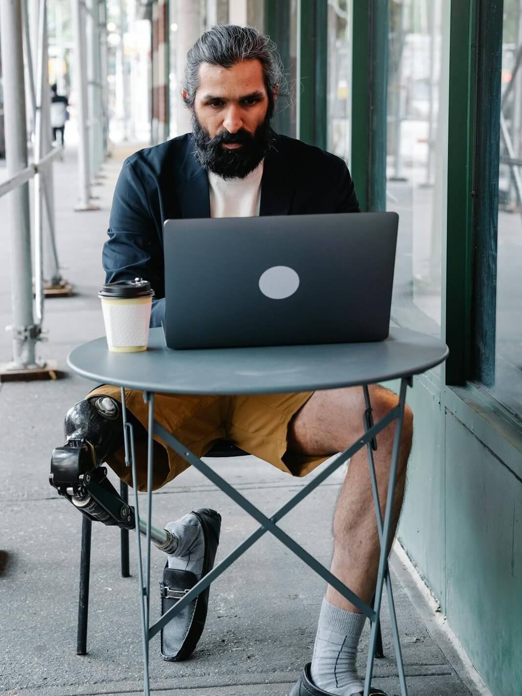 Focused Man with a prosthetic leg working on his Laptop